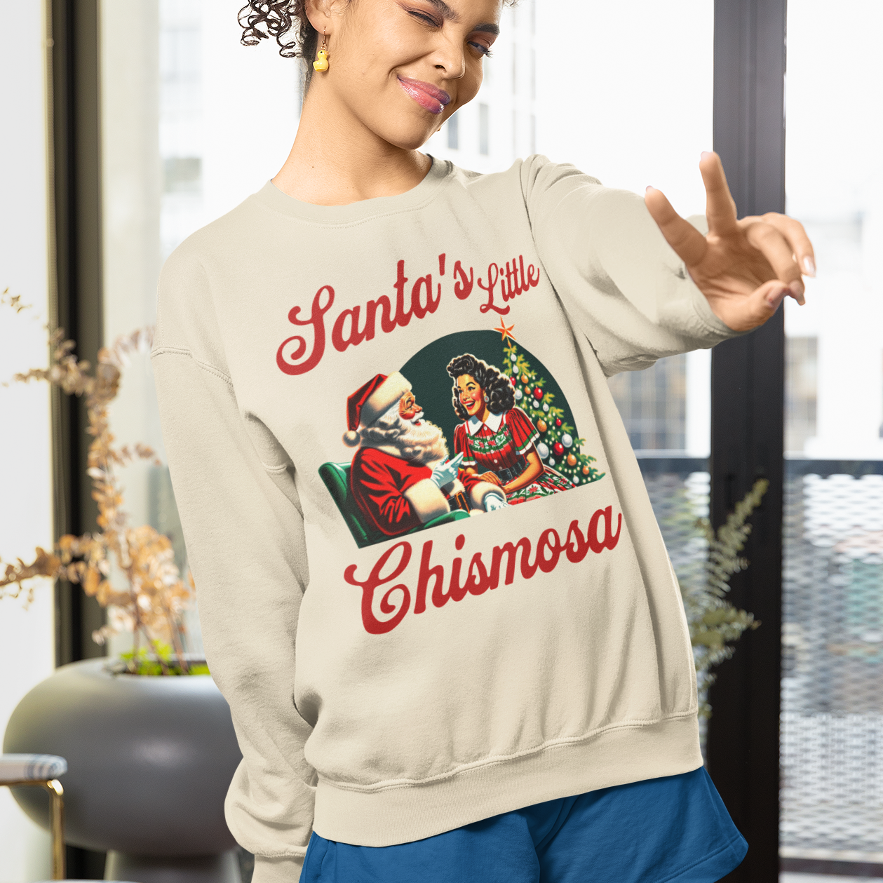 Woman wearing a festive sweatshirt with a Christmas design in a modern living room.
