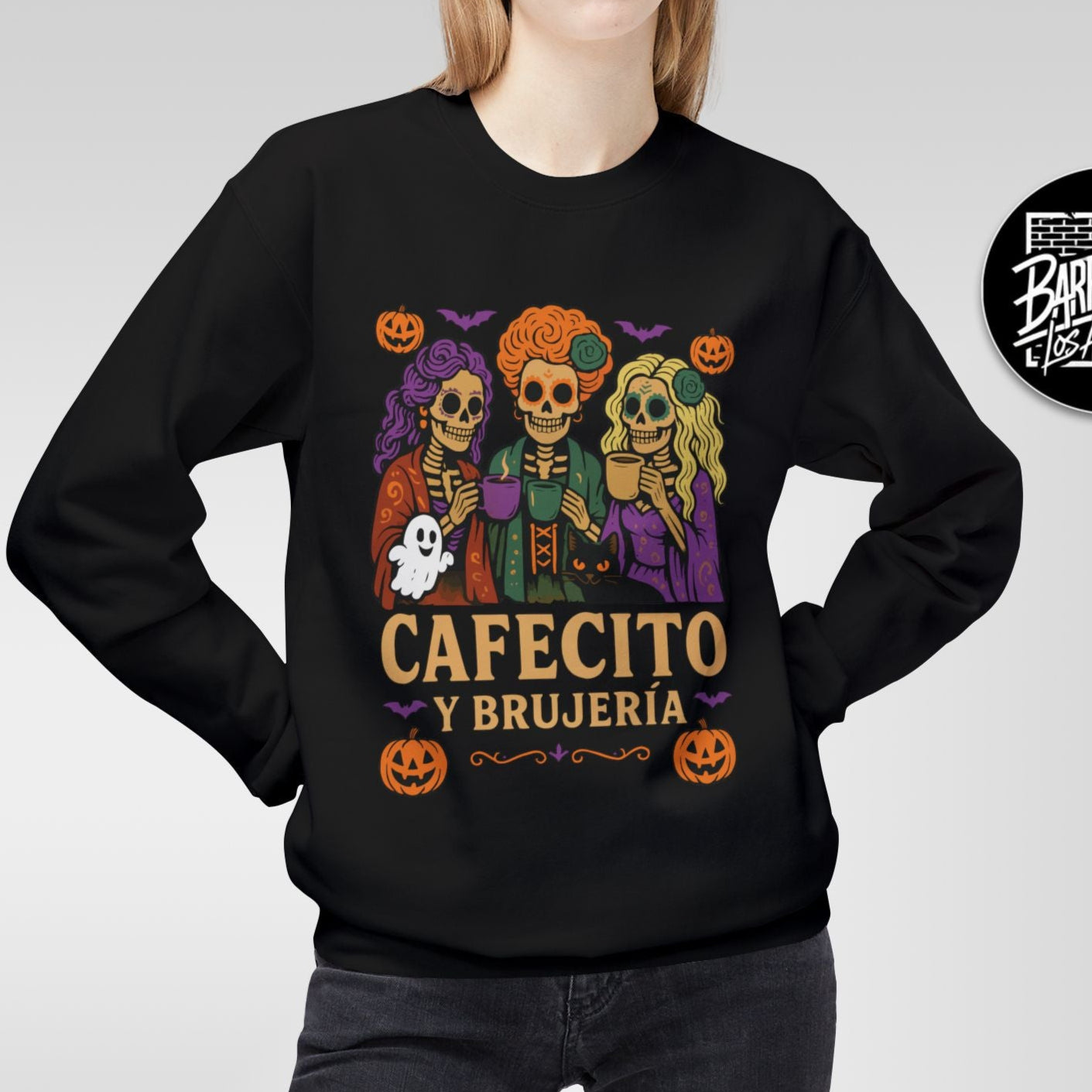 Person wearing a black sweatshirt with a colorful graphic and text, on a plain background.