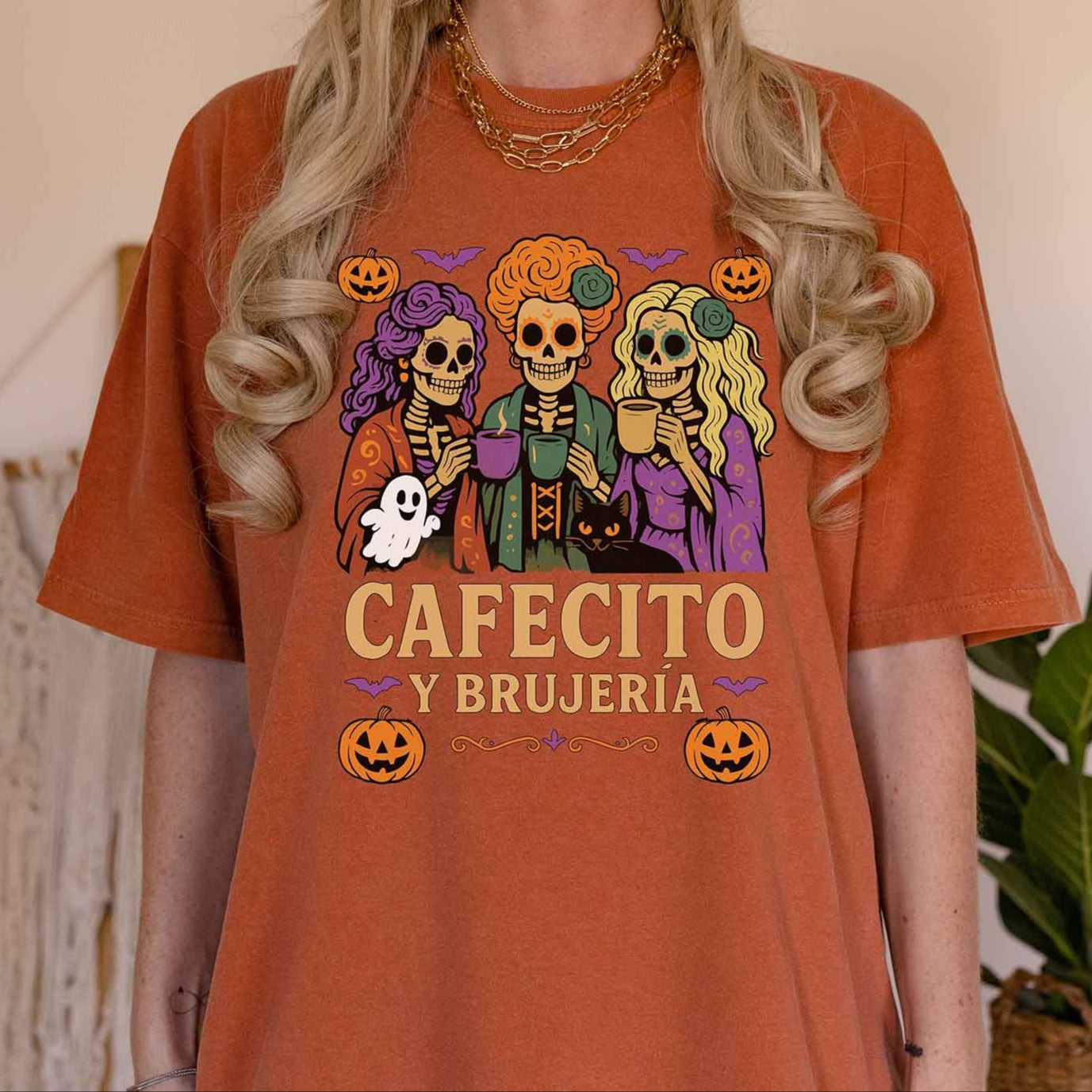 Person wearing a rust-colored t-shirt with Halloween-themed graphics and text.