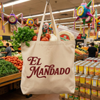 Tote bag with 'El Mandado' branding in a grocery store setting