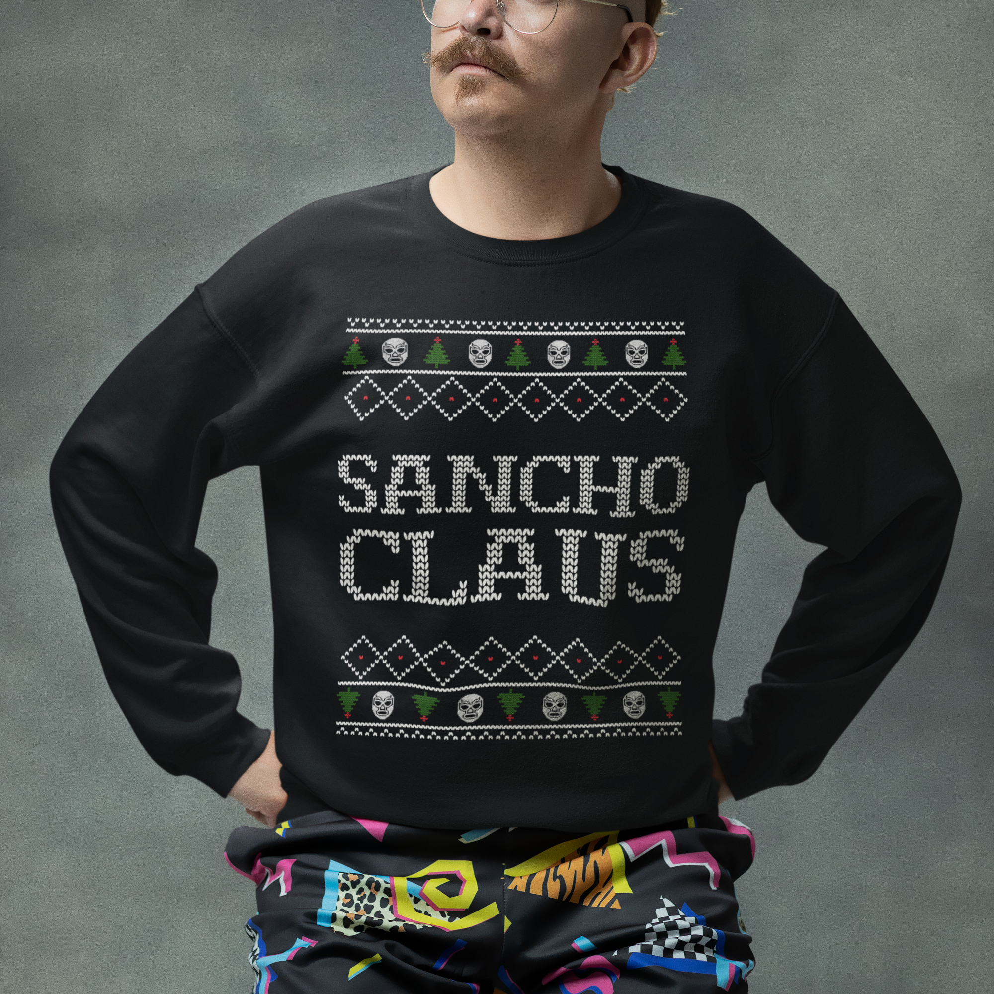 Person wearing a black sweater with 'Sancho Claus' text and colorful pants against a gray background