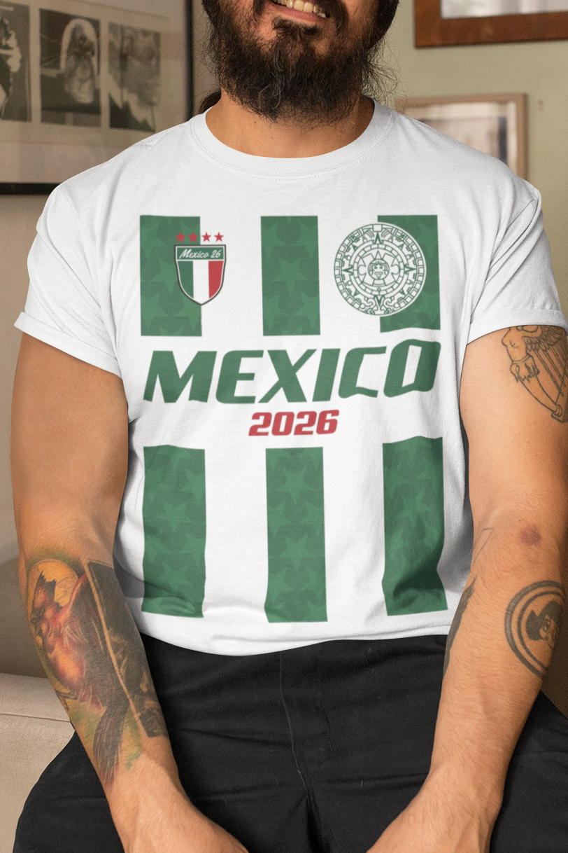 Man wearing a white t-shirt with 'Mexico 2026' design in a living room.