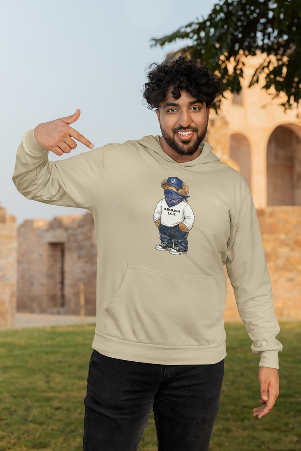 Man wearing a beige hoodie with a graphic design outdoors