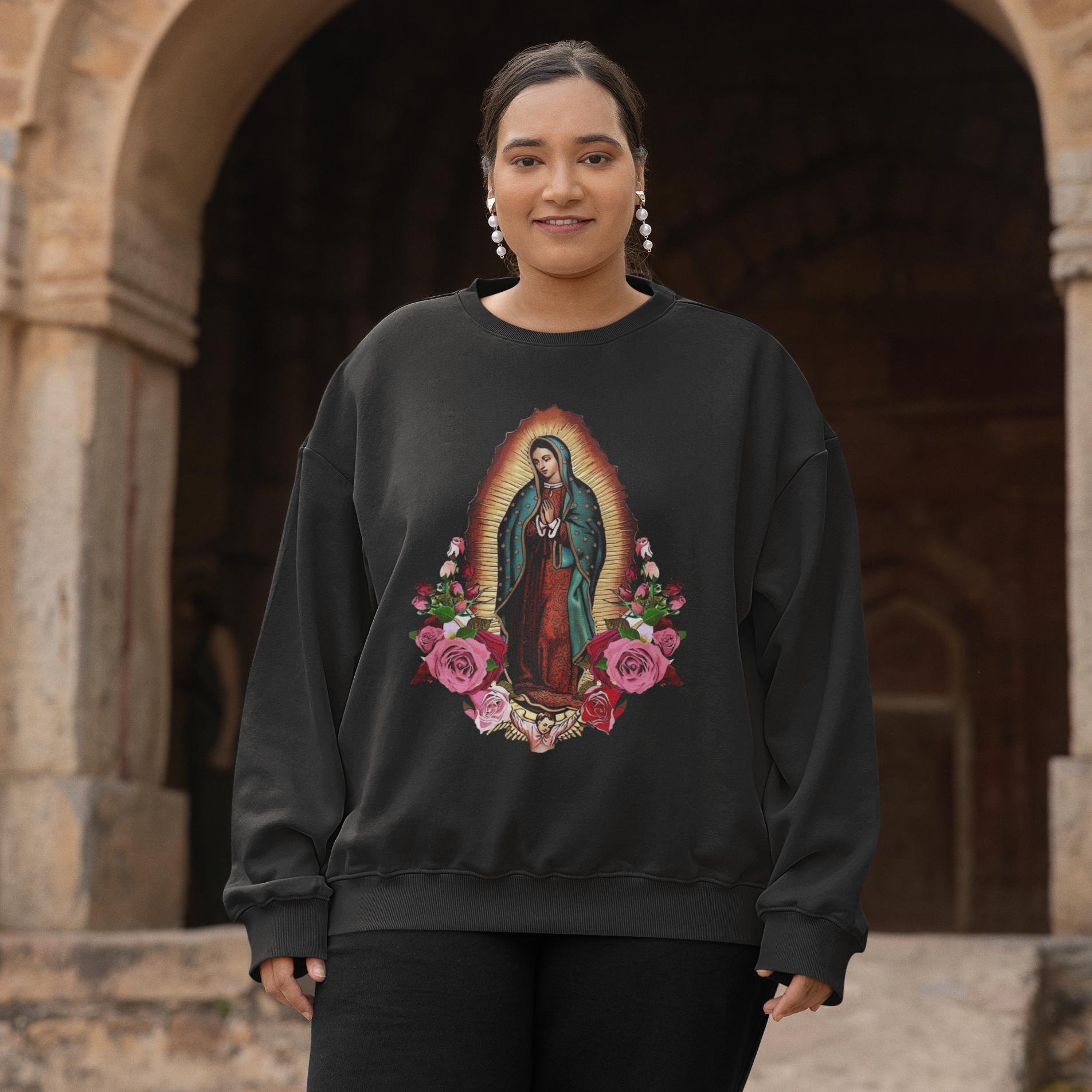 Person wearing a black sweatshirt with a colorful graphic design in front of an archway.